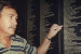 Peter Sophios pointing to his father Dave's entry on the Welcome Wall 