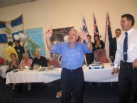 George Kalligeros, proprietor of the Kapsali Restaurant conducting the audience while they sing 