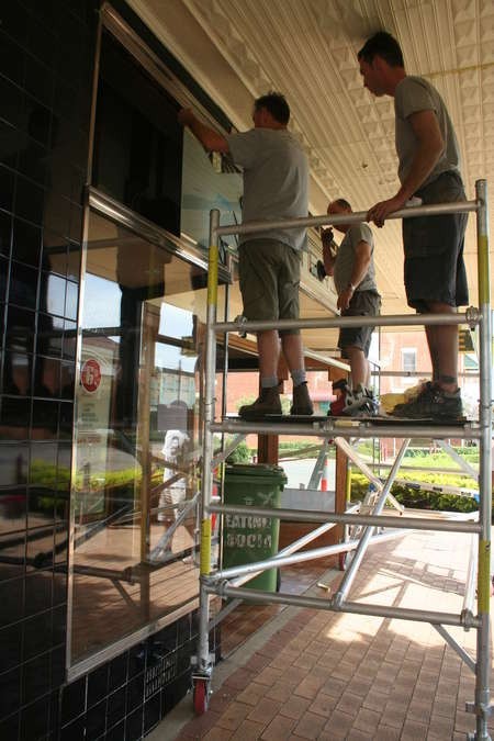 Erecting the sign in front of the cafe (eastern face) 