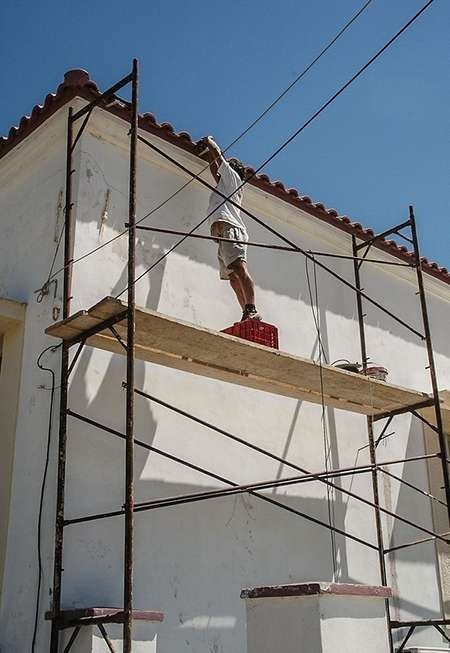 Orestes performing the difficult task of affixing a gutter to the Kytherian Municipal Library 