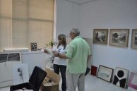 Takis Efstathiou and Theodora Georgaki, who is in charge of Art exhibits at the Cultural Centre examining new art work donated by Takis. 